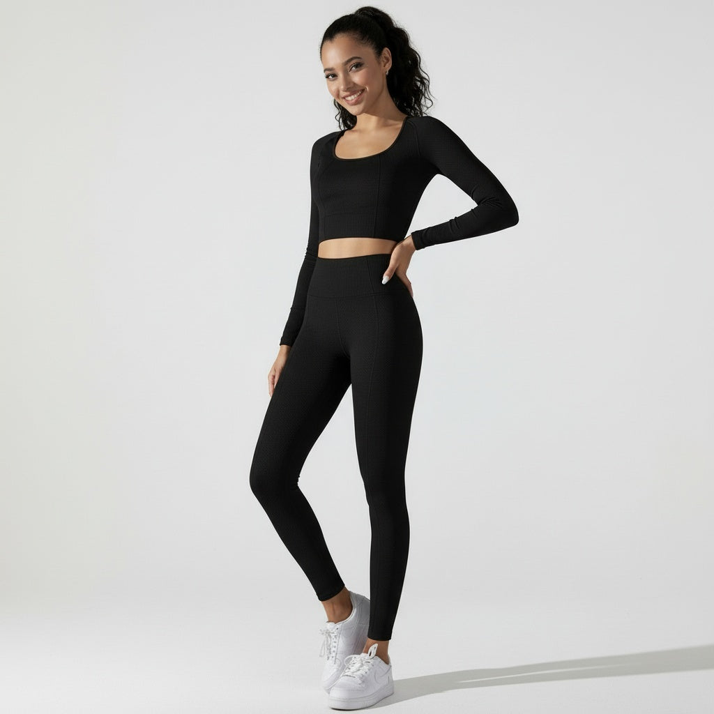 Fitness Set Isa in Schwarz, bestehend aus Cropped Langarmshirt und Highwaist-Leggings aus dickem Material, das die natürliche Körperform unterstützt.